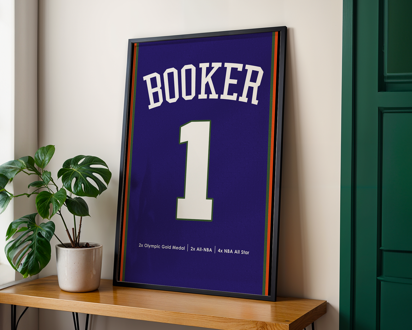 Framed sports jersey with 'Booker' and number '1' on a wooden shelf.