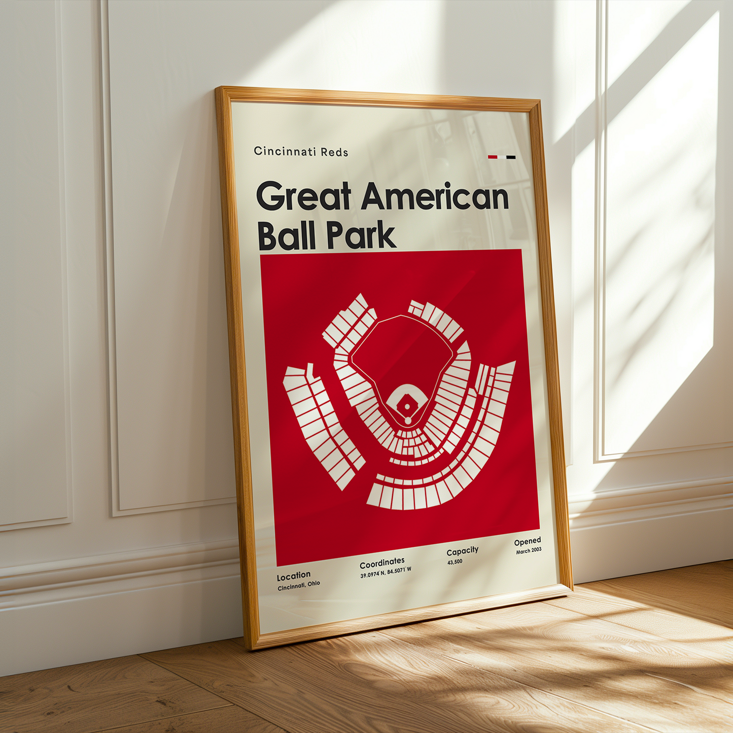 Framed poster of Great American Ball Park with Cincinnati Reds logo on a wooden floor.