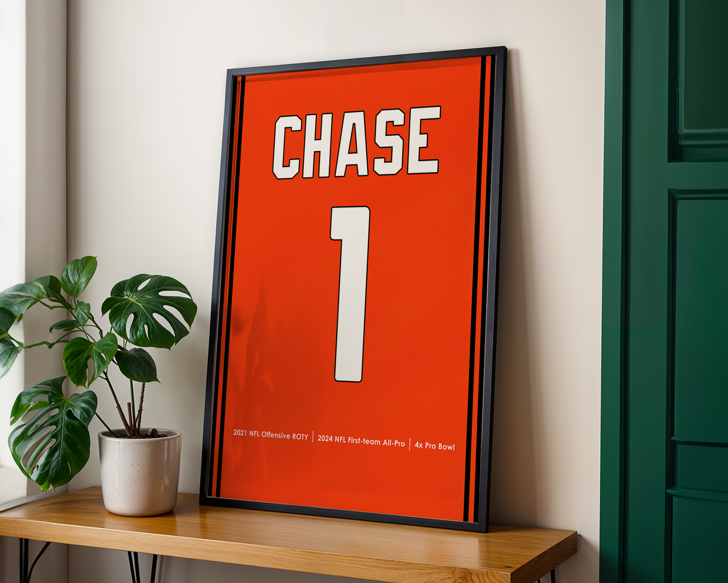 Framed sports jersey with 'CHASE' and number '1' on a wooden shelf.