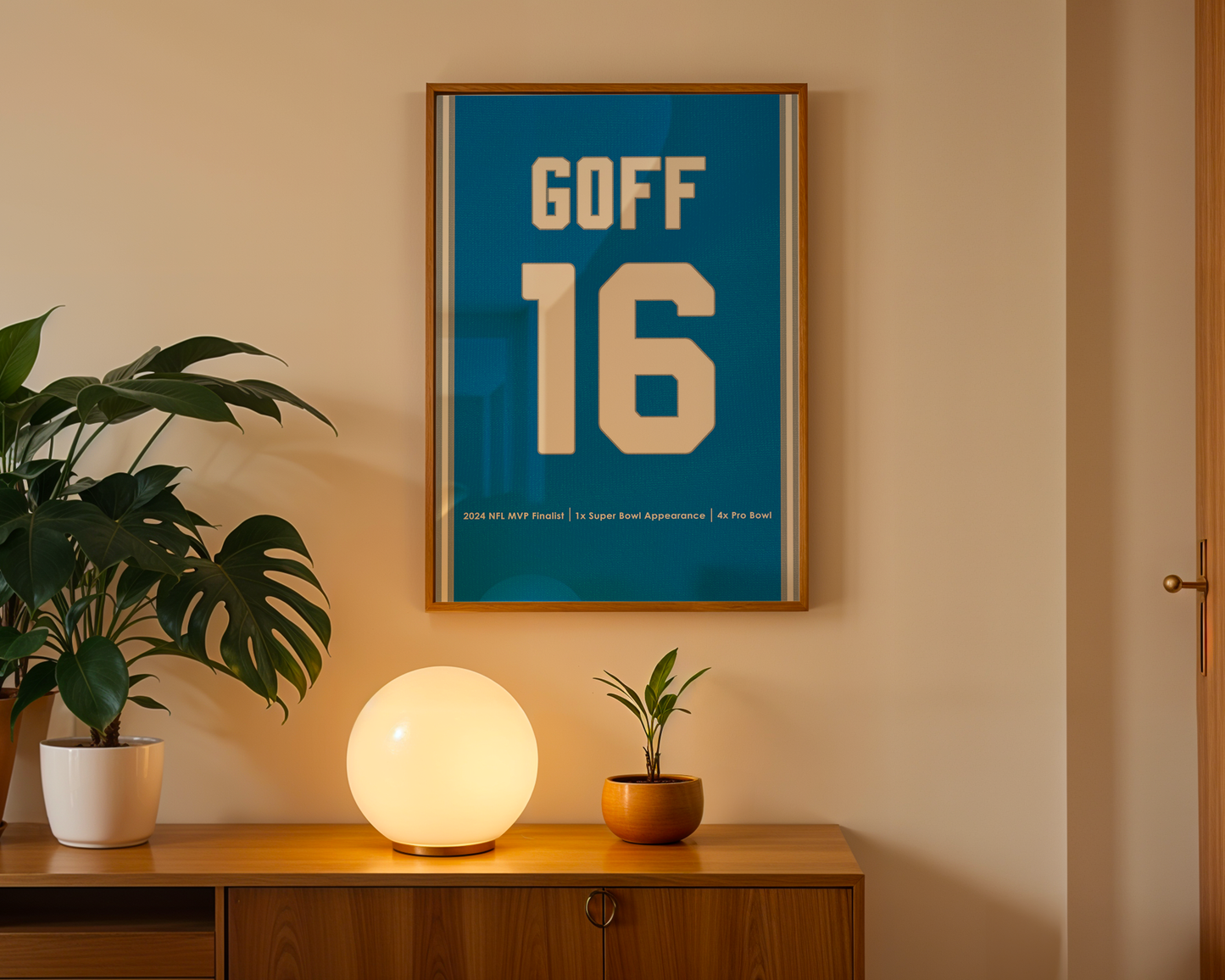 Framed poster with 'GOFF 16' on a wall above a wooden cabinet with decorative items.