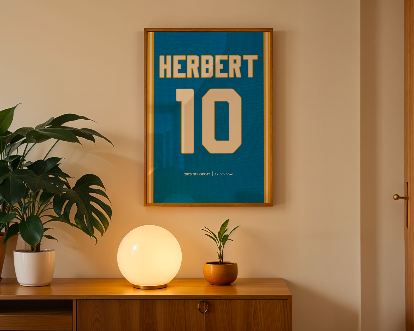 Framed poster with 'HERBERT 10' on a wall above a wooden cabinet with decorative items.