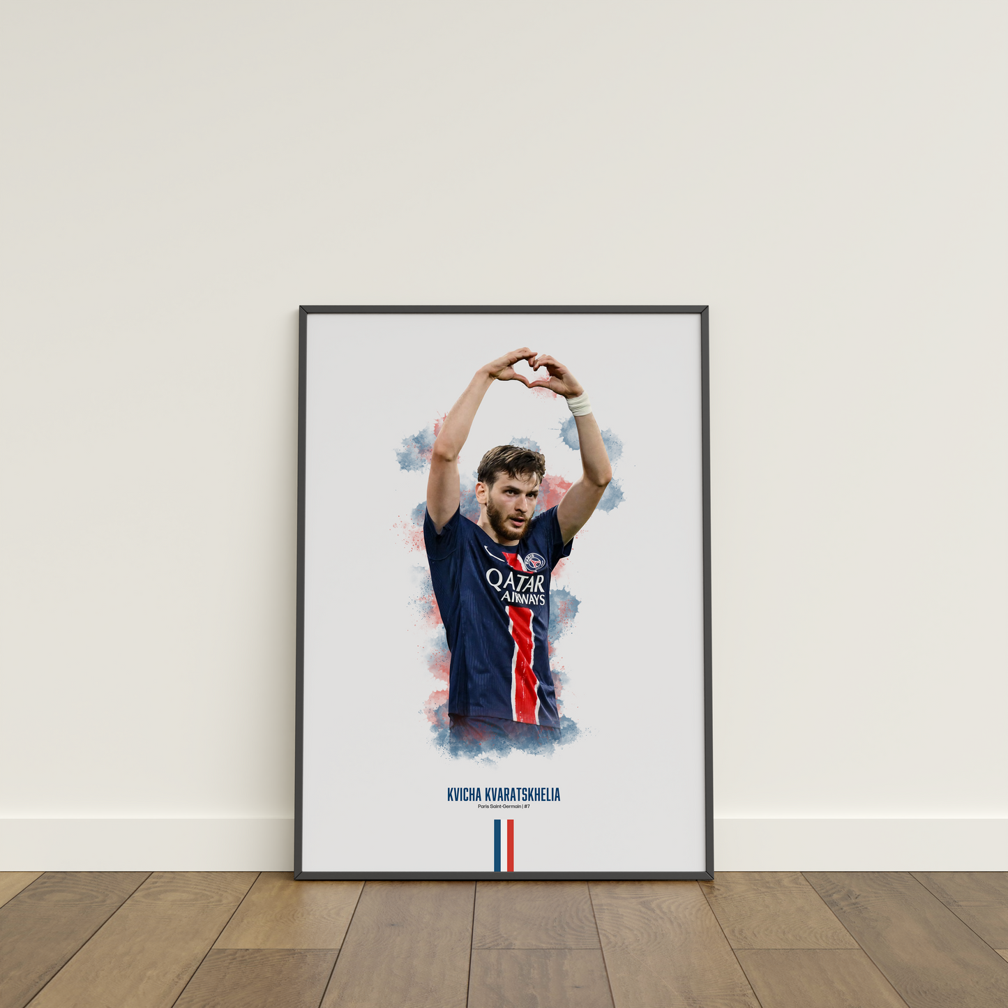 Framed poster print of soccer player Kvicha Kvaratskhelia, wearing a PSG jersey, on a white wall.