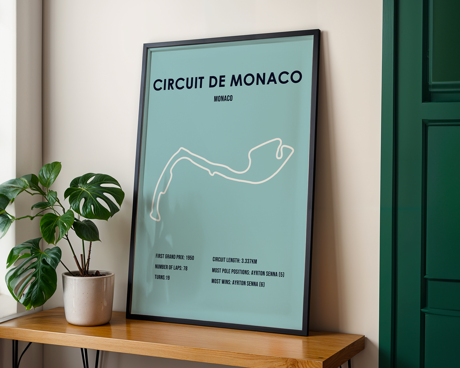 Framed poster of Circuit de Monaco on a wooden shelf with a plant