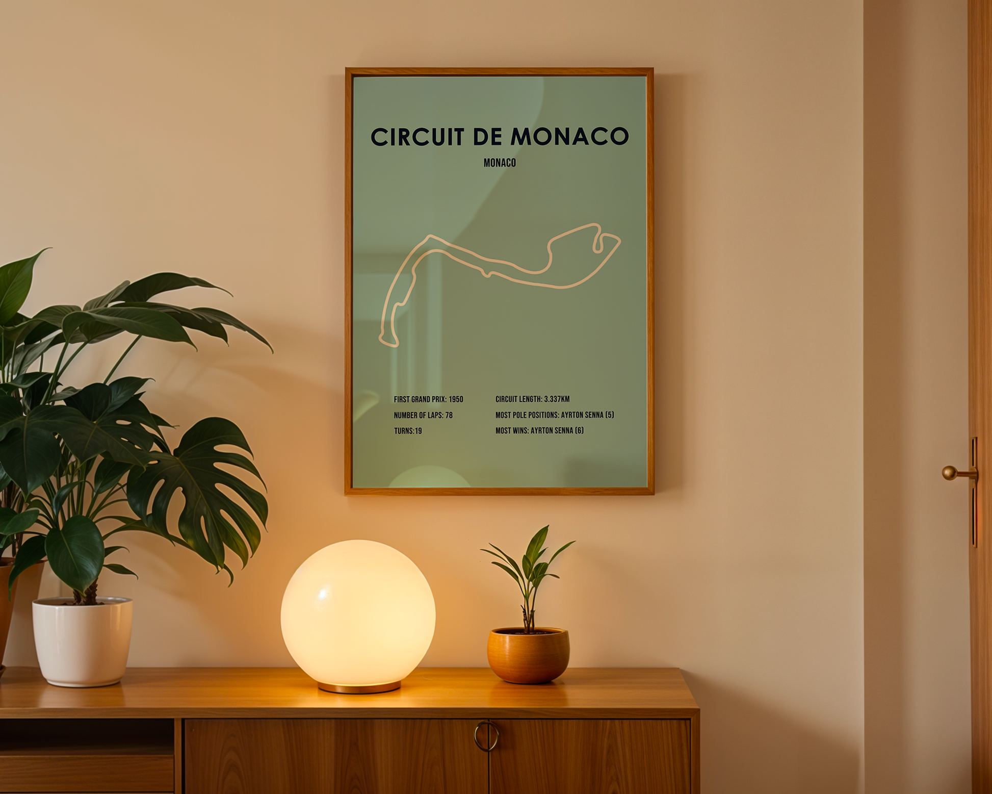 Framed poster of Circuit de Monaco on a wall above a wooden cabinet with decorative items.