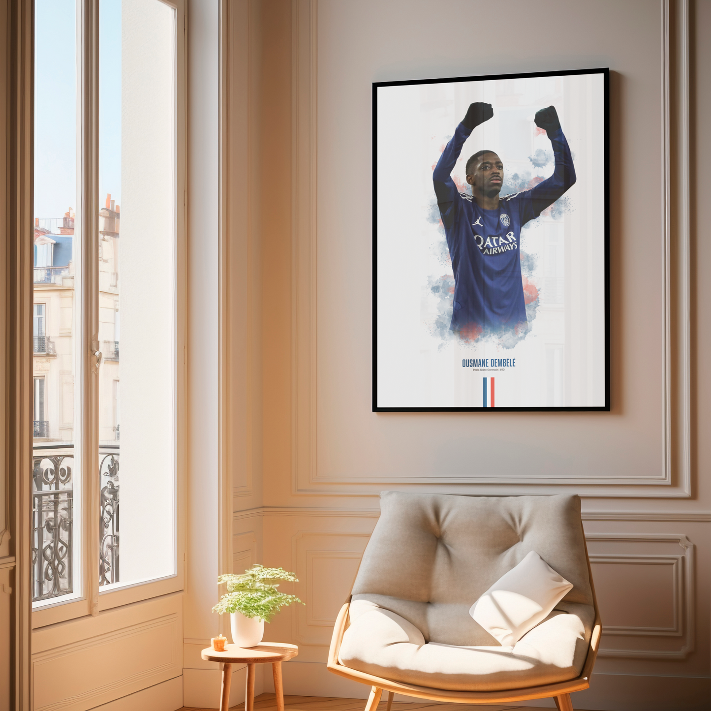 Framed poster print of soccer player Ousmane Dembele, wearing a PSG jersey, on a wall above a chair.