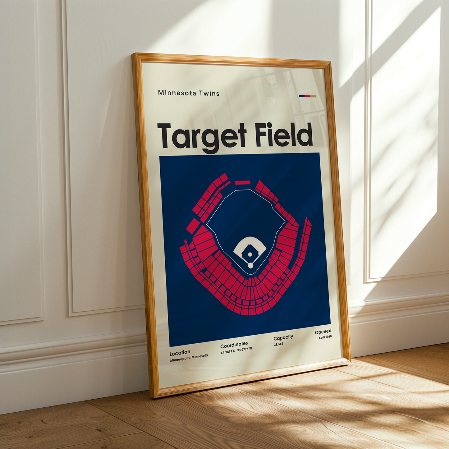 Framed poster of Target Field with Minnesota Twins logo on a wooden floor.
