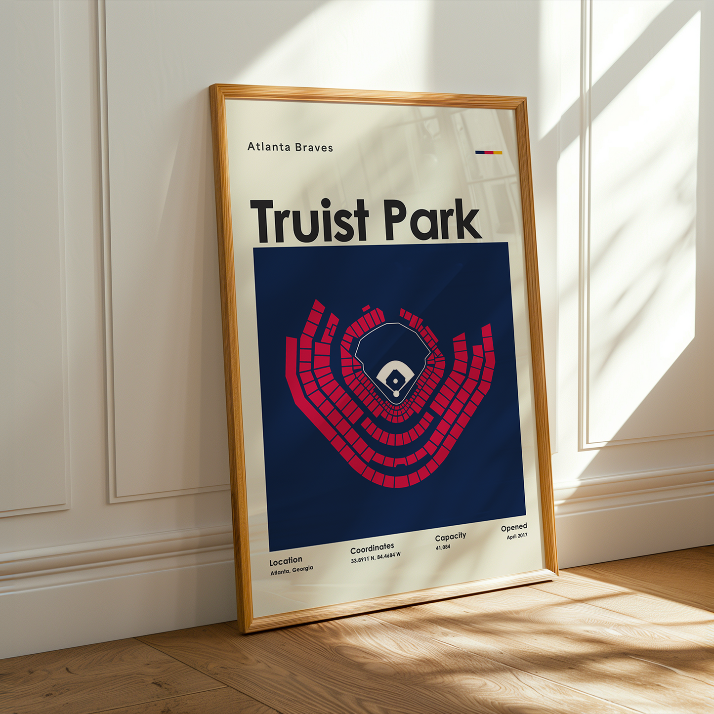 Framed poster of Truist Park with Atlanta Braves logo on a wooden floor.