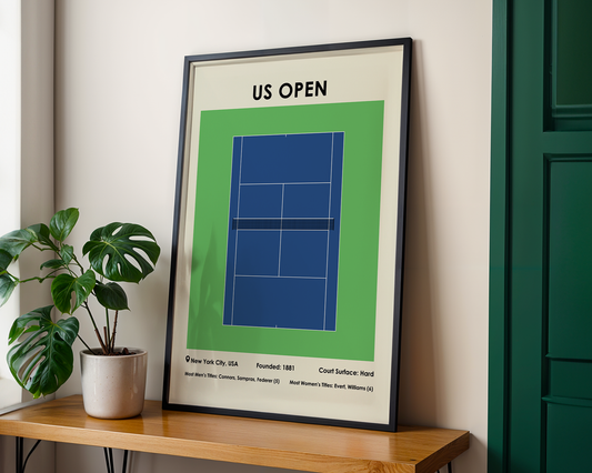 Framed poster of a tennis court layout with 'US Open' text on a wall next to a plant.