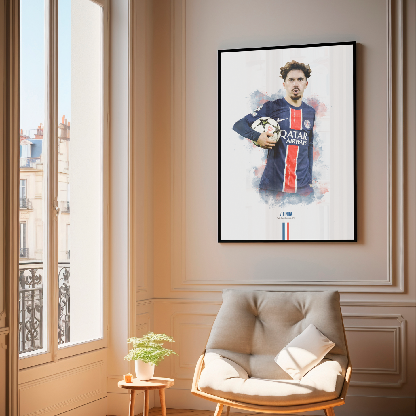 Framed poster print of soccer player Vitinha, wearing a PSG jersey, on a wall above a chair.