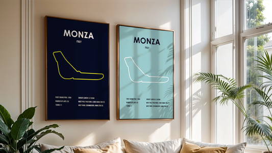 two framed posters of monza race track hanging on a wall next to a window