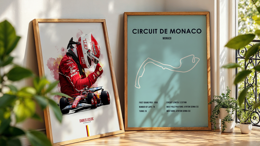 two framed formula 1 posters leaning on a wall next to a plant