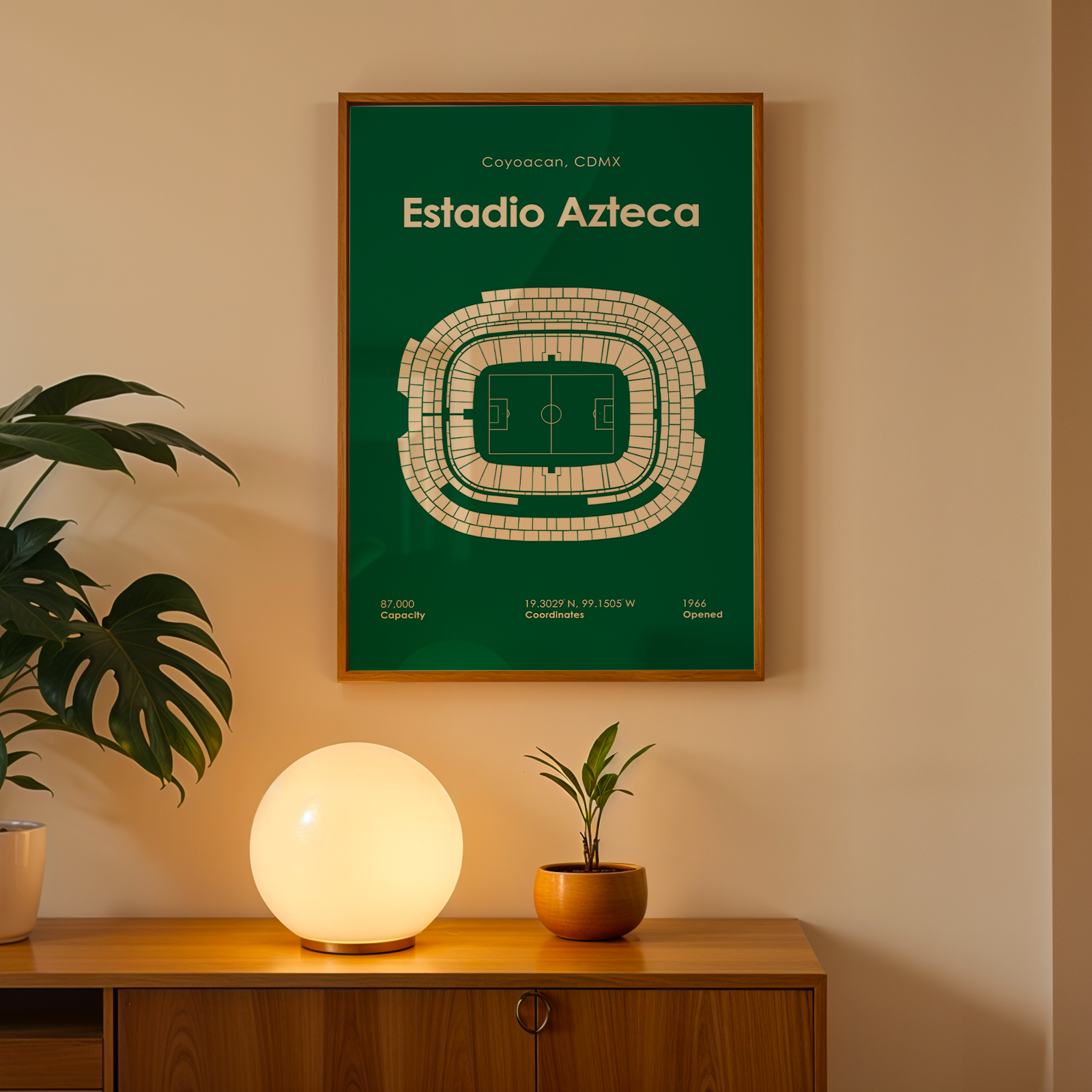 Framed poster of Estadio Azteca on a wall above a wooden cabinet with decorative items.