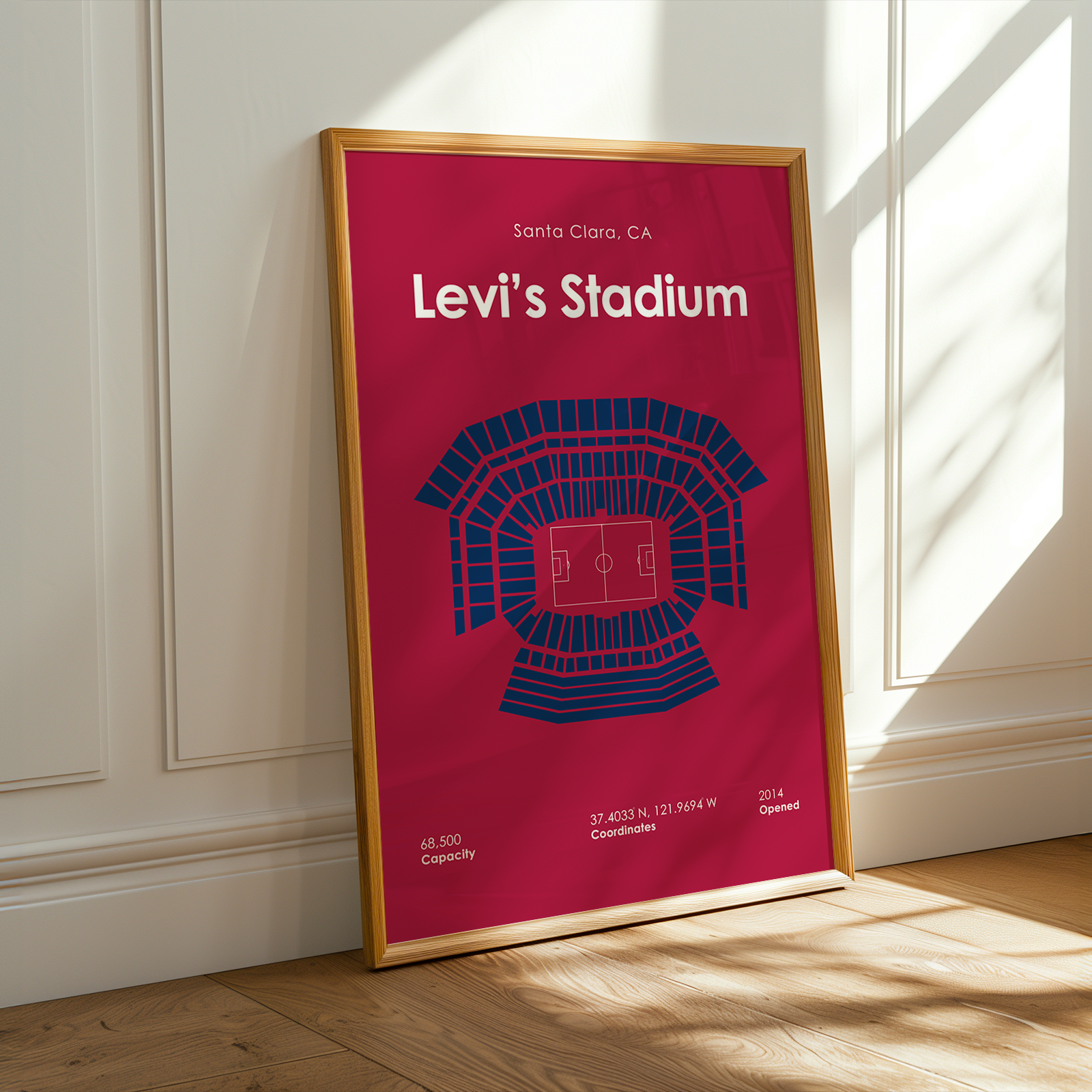 Framed poster of Levi's Stadium with a red background and gold frame on a wooden floor.
