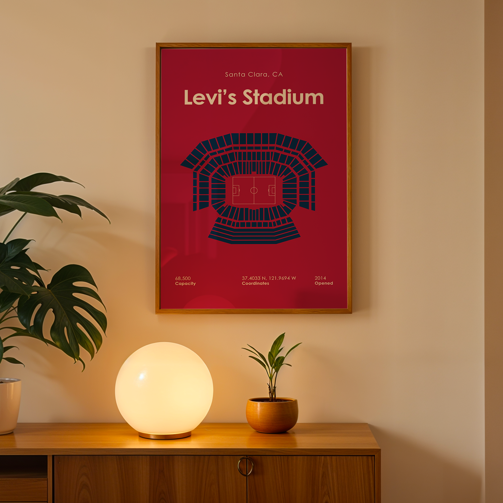 Framed Levi's Stadium poster on a wall above a wooden cabinet with decorative items.