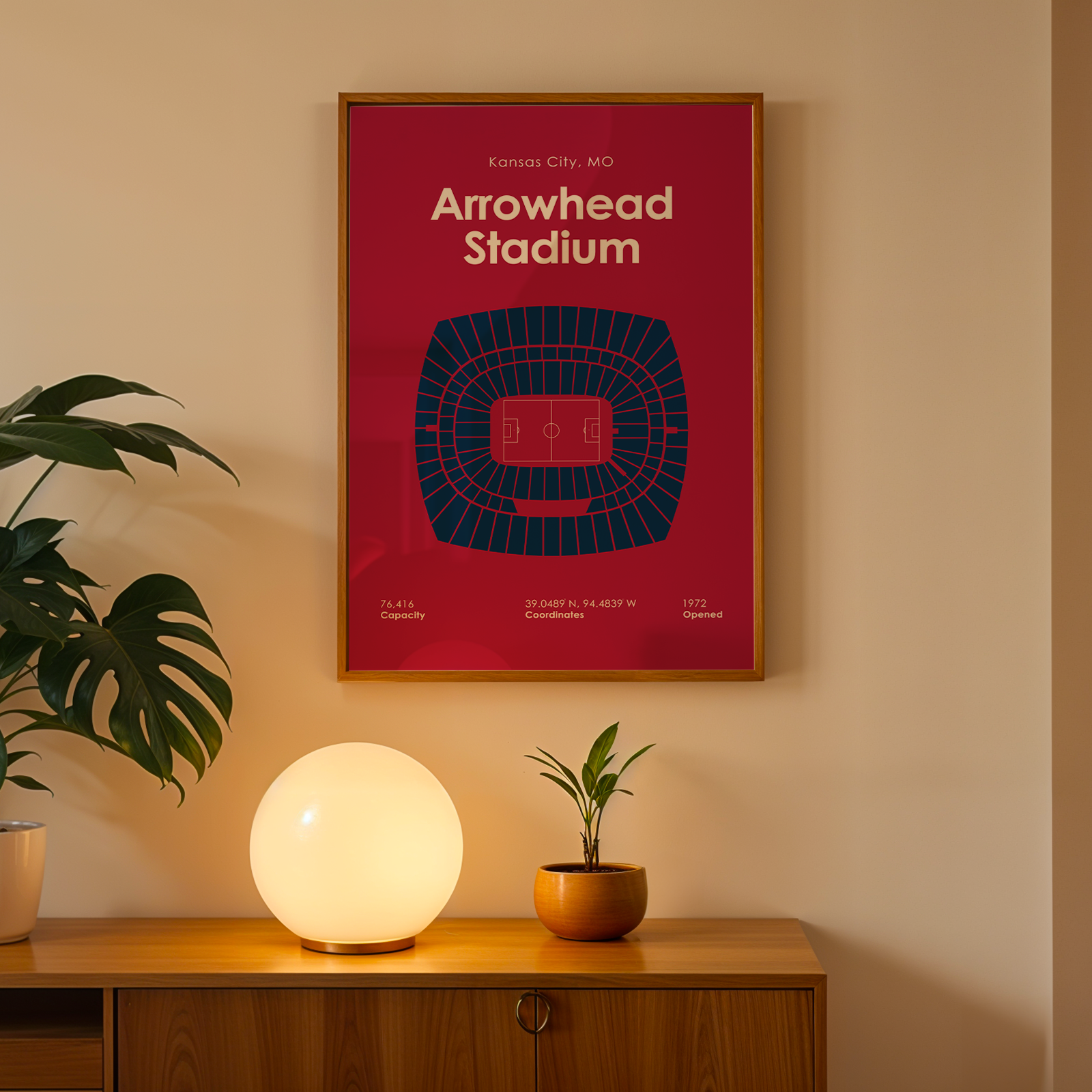 Framed poster of Arrowhead Stadium on a wall above a wooden cabinet with decorative items.
