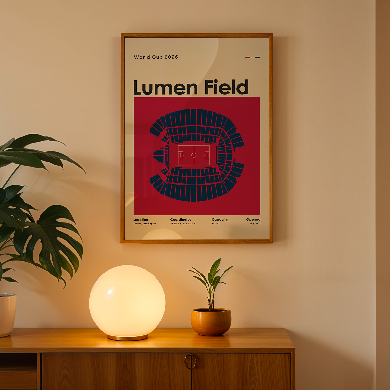 Framed poster of AT&T Stadium on a wall above a wooden cabinet with decorative items.