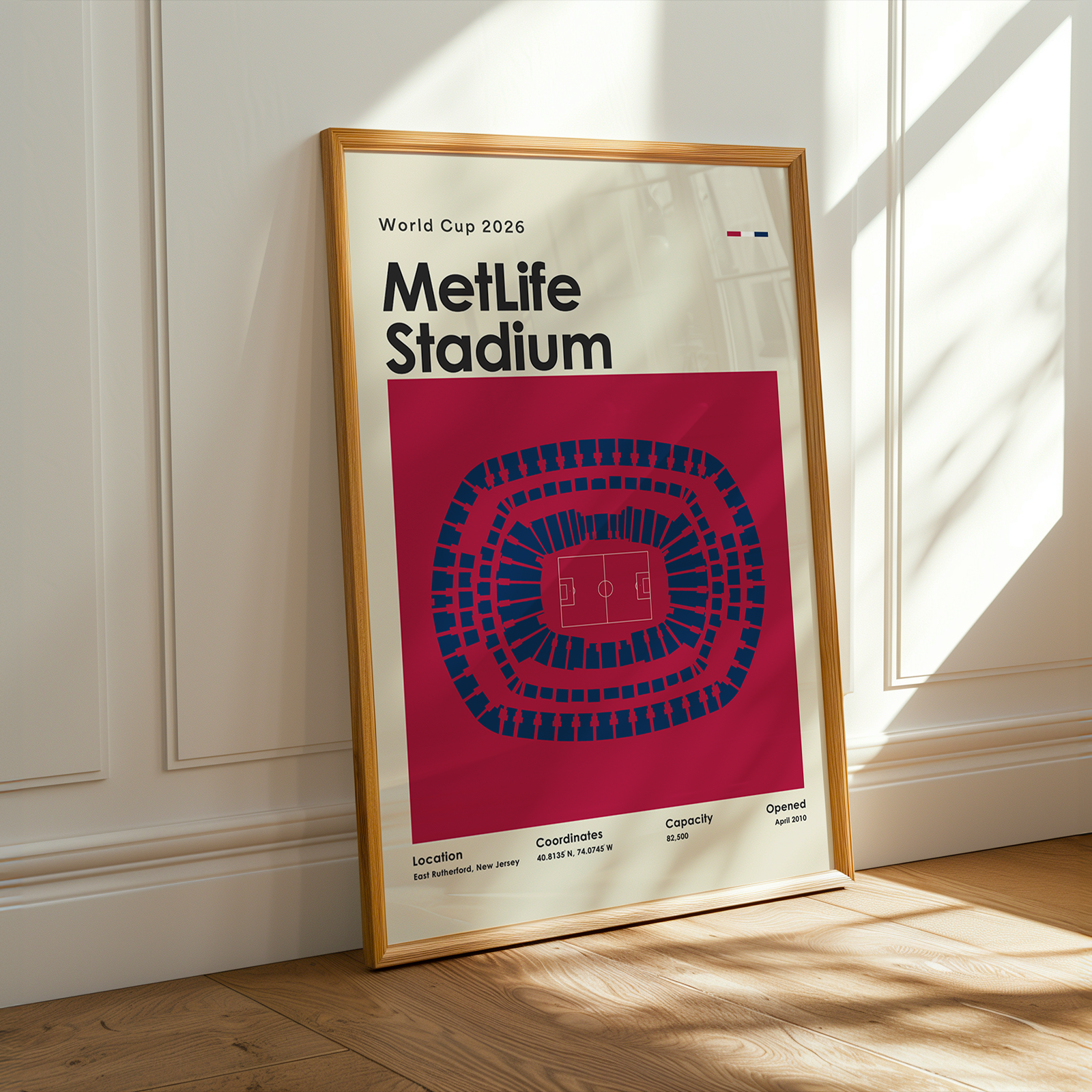Framed poster of Metlife Stadium on a wall with sunlight casting shadows.