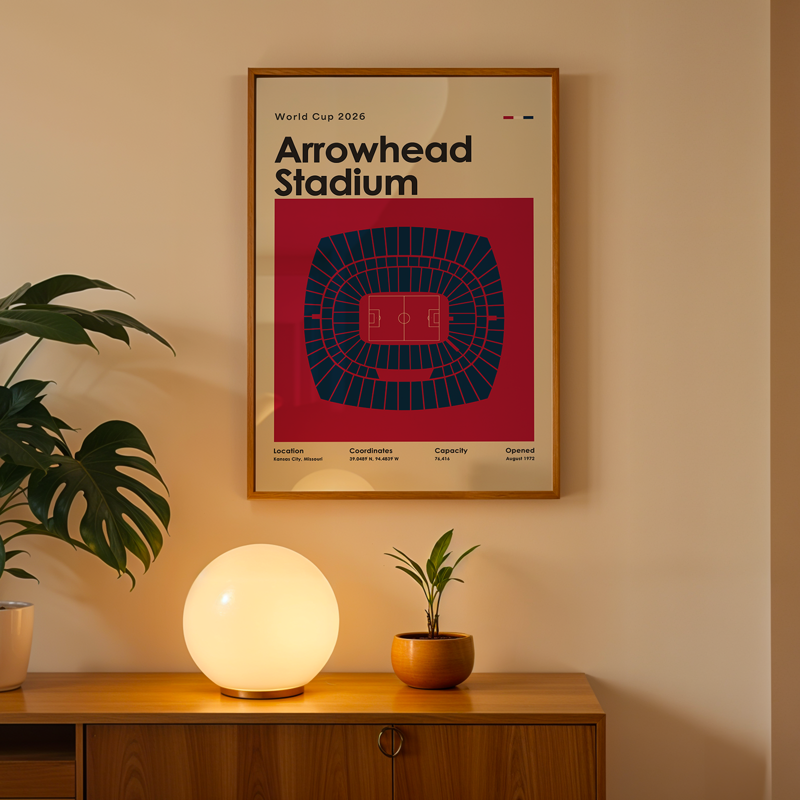 Framed poster of Arrowhead Stadium on a wall above a wooden cabinet with decorative items.