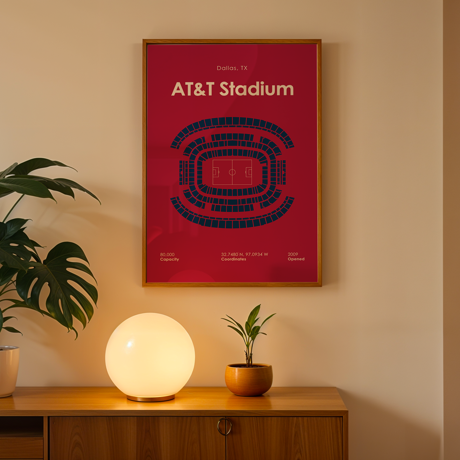 Framed poster of AT&T Stadium on a wall above a wooden cabinet with decorative items.