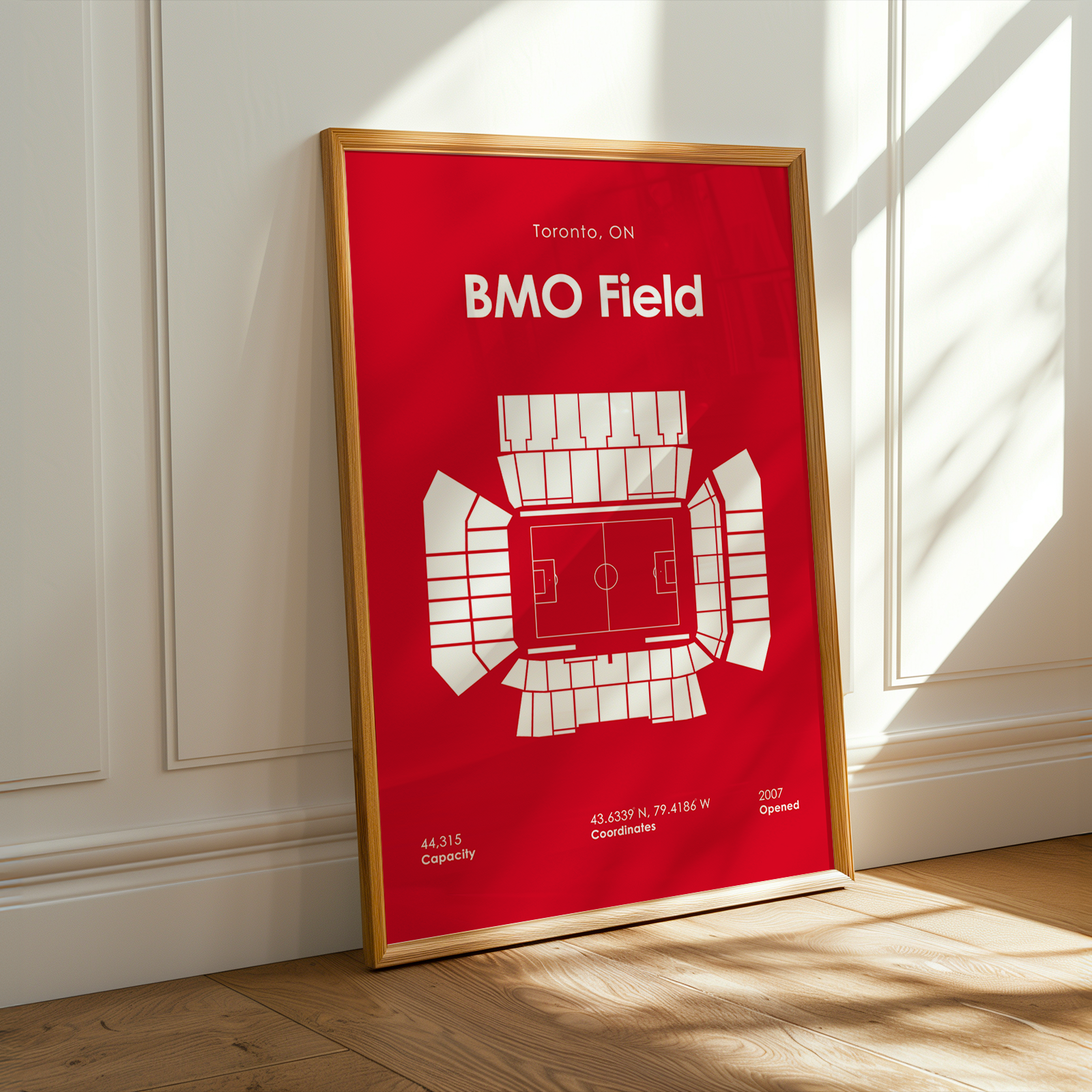 Framed poster of BMO Field on a wall with sunlight casting shadows.