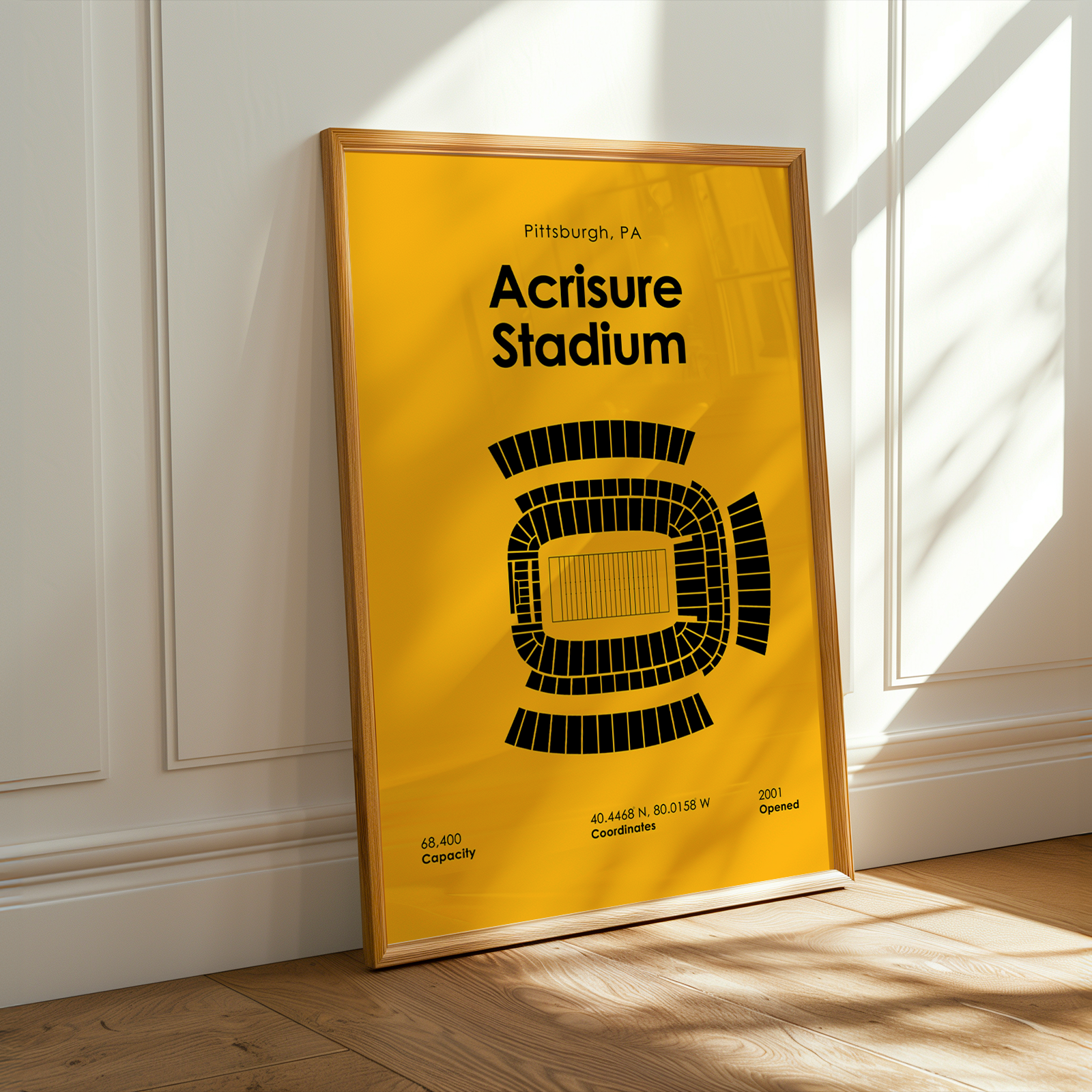 Framed poster of Acrisure Stadium with yellow background and black text, leaning against a white wall.