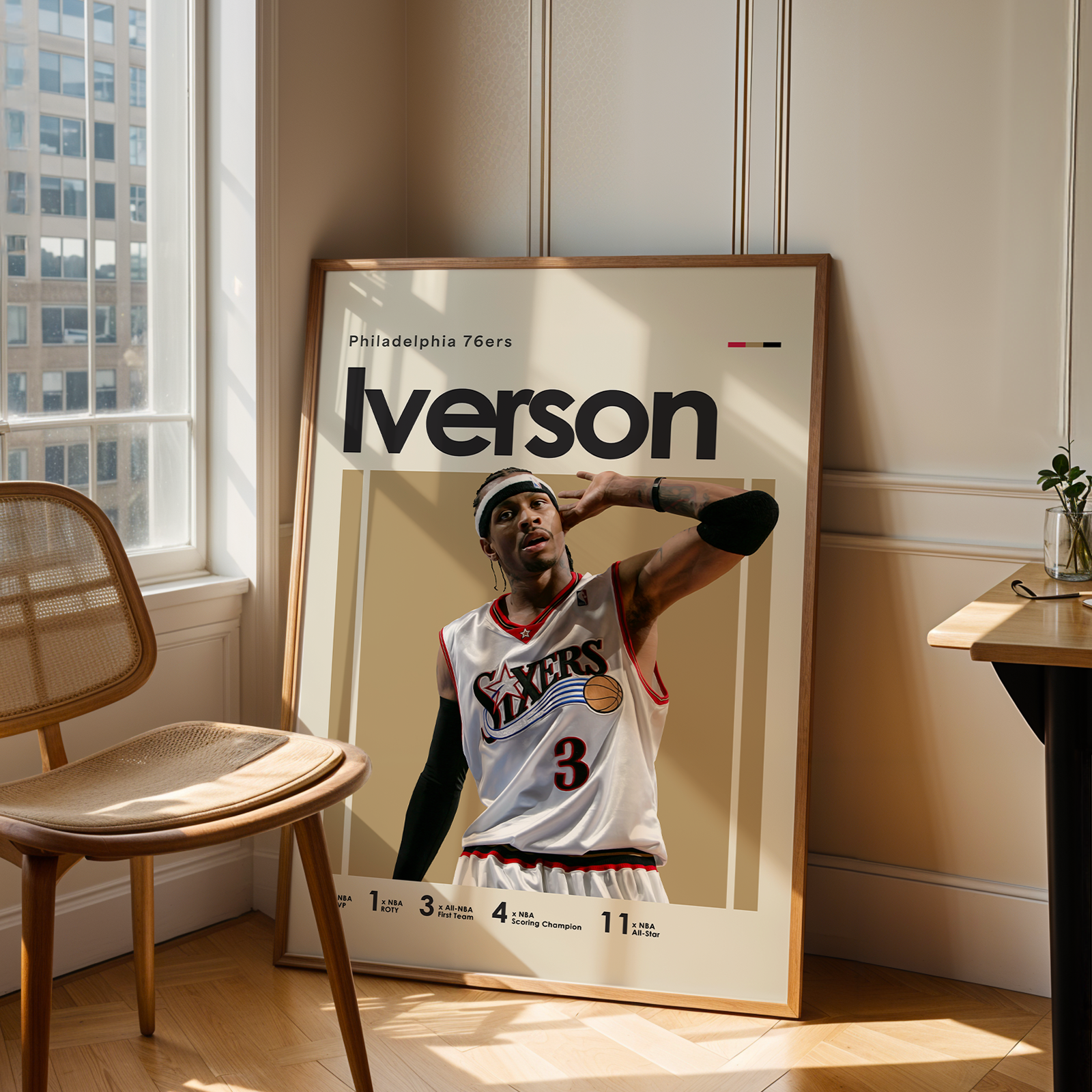 Framed poster of a basketball player with 'Iverson' on a wall in a room with a chair and table.