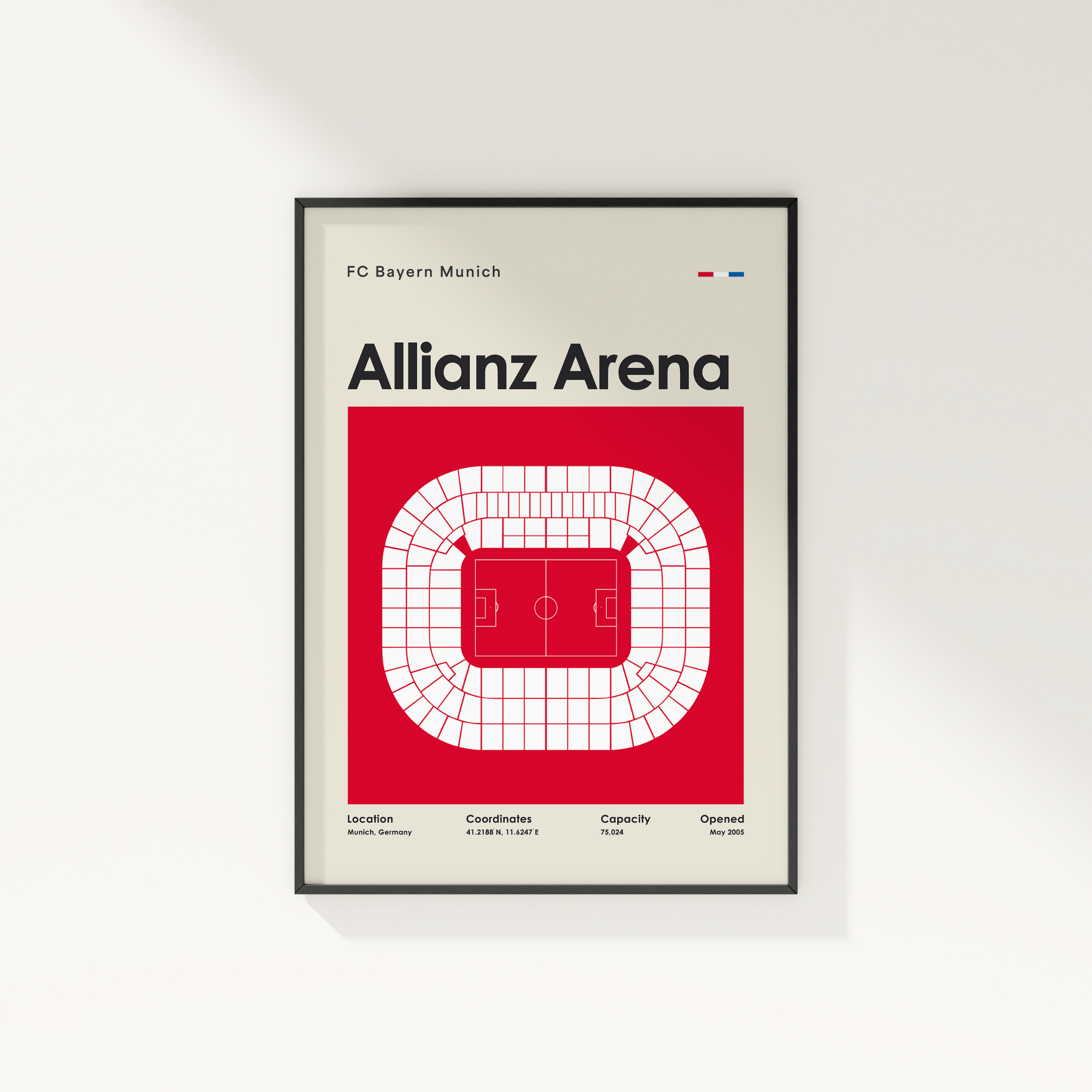 Framed poster of Allianz Arena with FC Bayern Munich branding on a white wall.