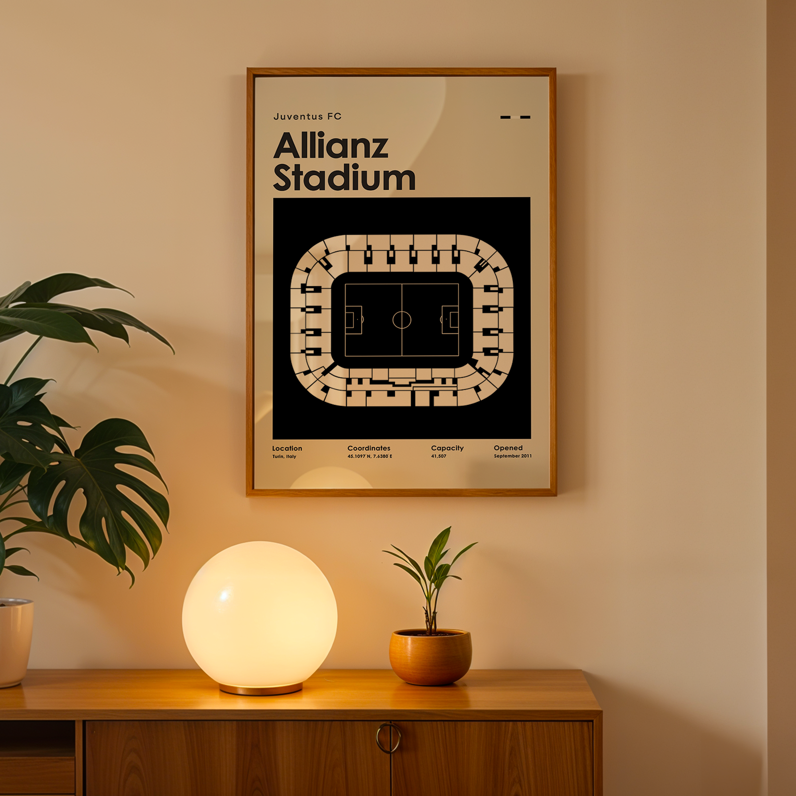 Framed poster of Allianz Stadium on a wall above a wooden cabinet with decorative items.