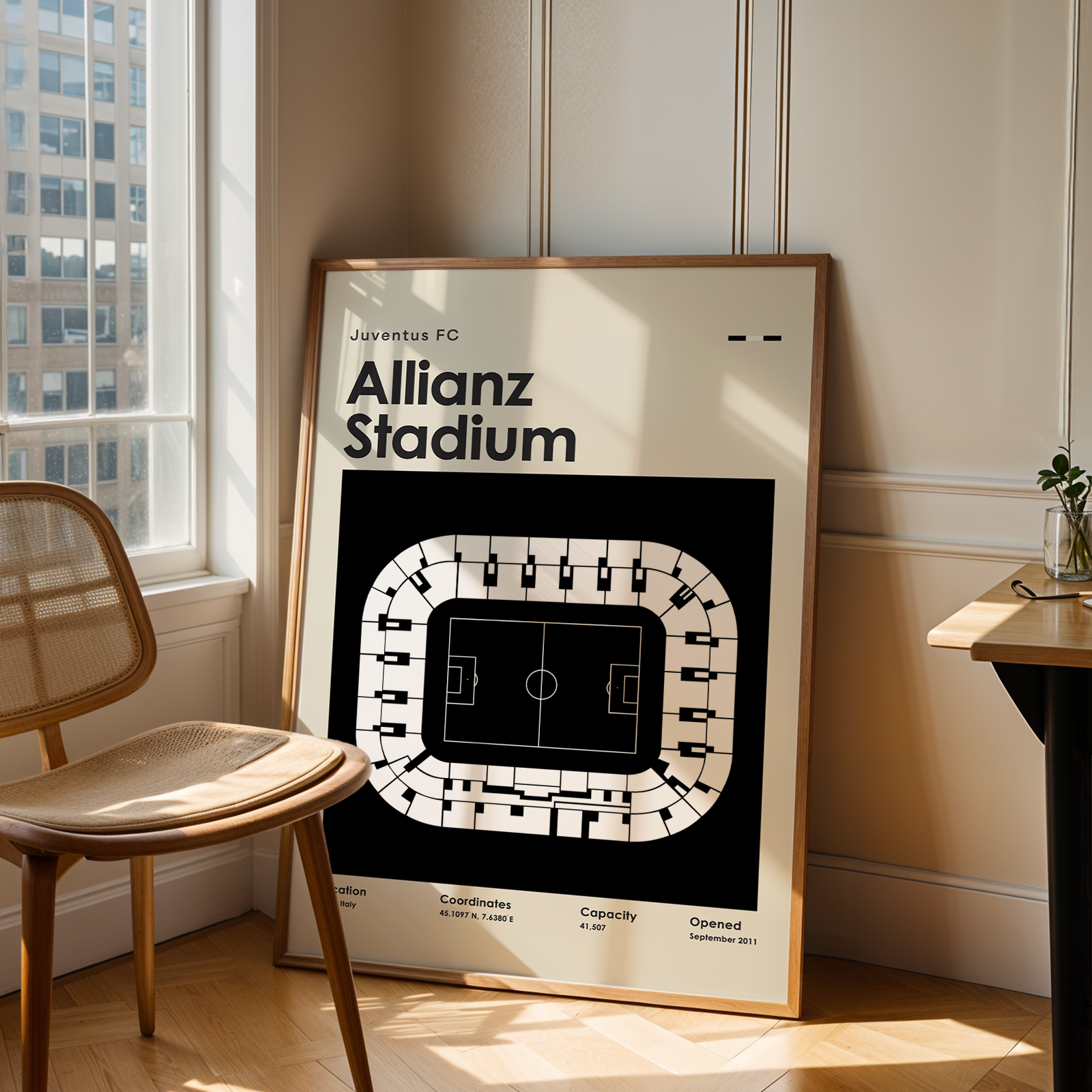 Framed poster of Allianz Stadium in a room with a chair and window.