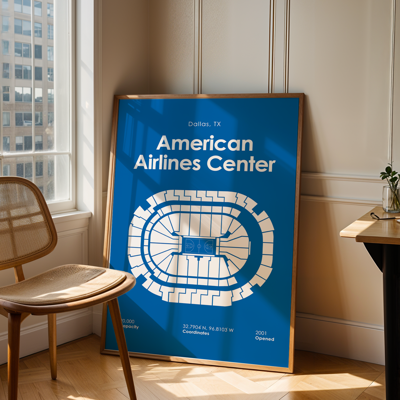 Framed poster of American Airlines Center in a room with a chair and table.