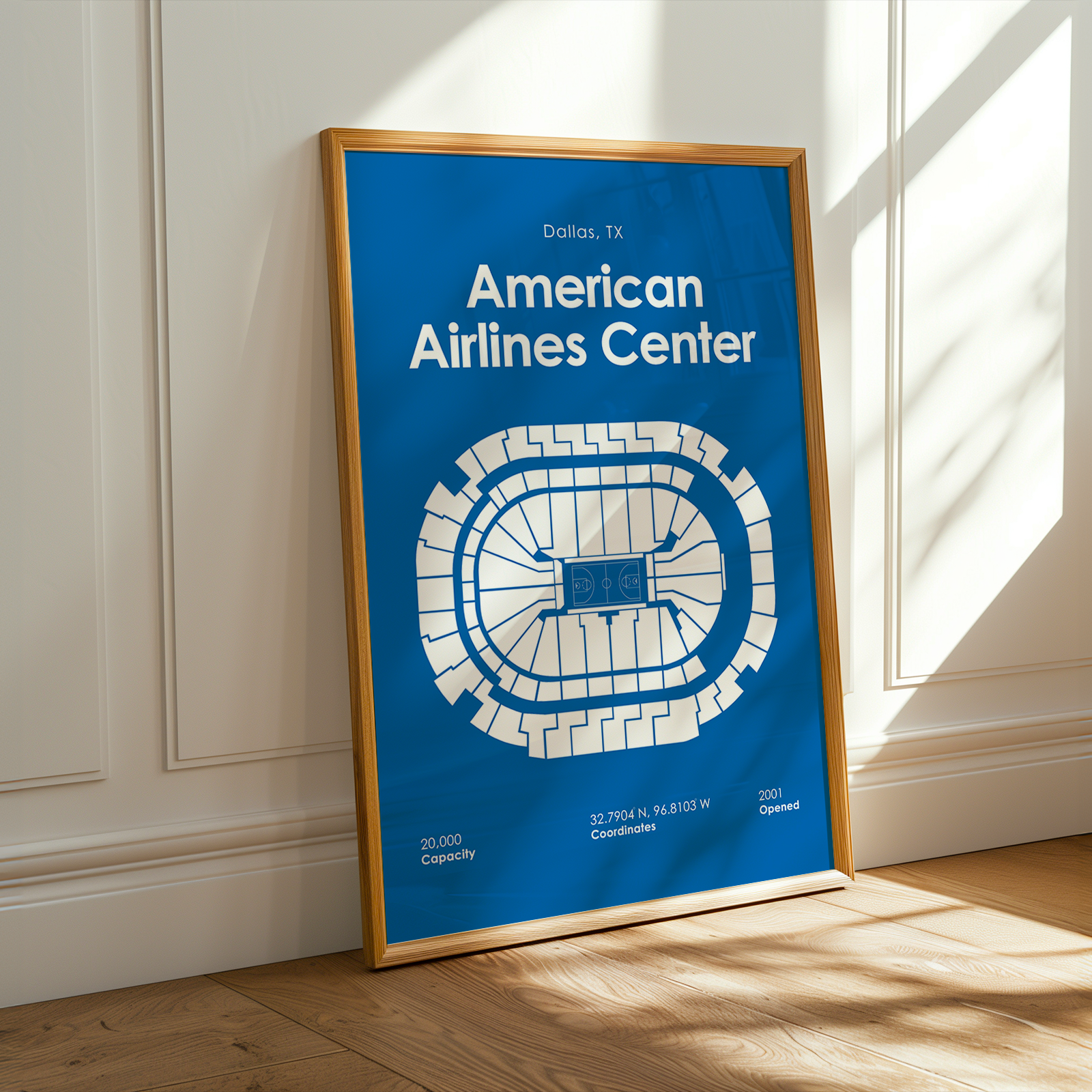 Framed poster of American Airlines Center layout on a wooden floor with sunlight casting shadows.