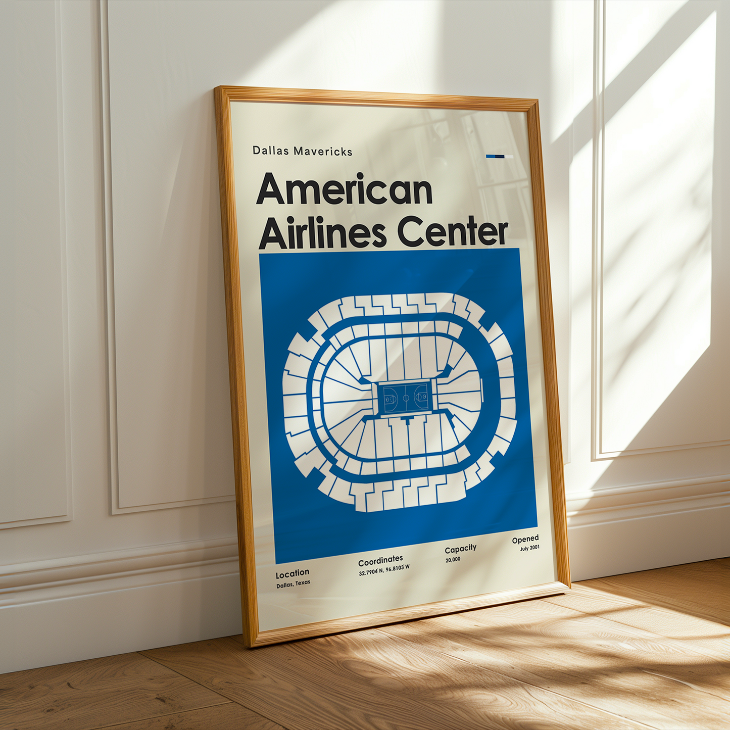 Framed poster of American Airlines Center on a wooden floor with sunlight streaming through a window.