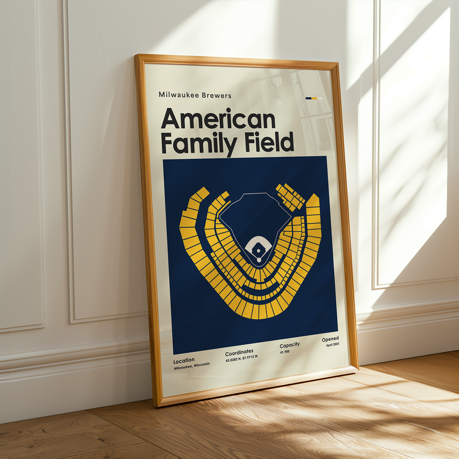Framed poster of American Family Field with a blue and yellow design on a white wall.