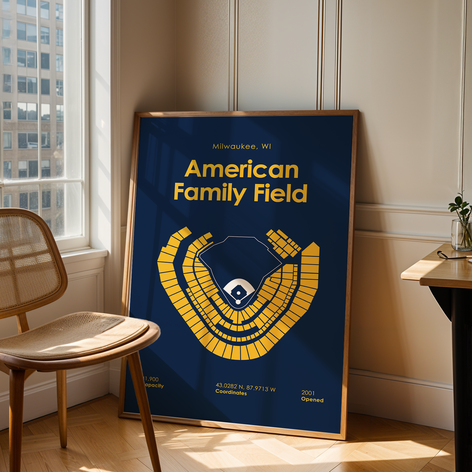 Framed poster of American Family Field in a room with a window and chair.