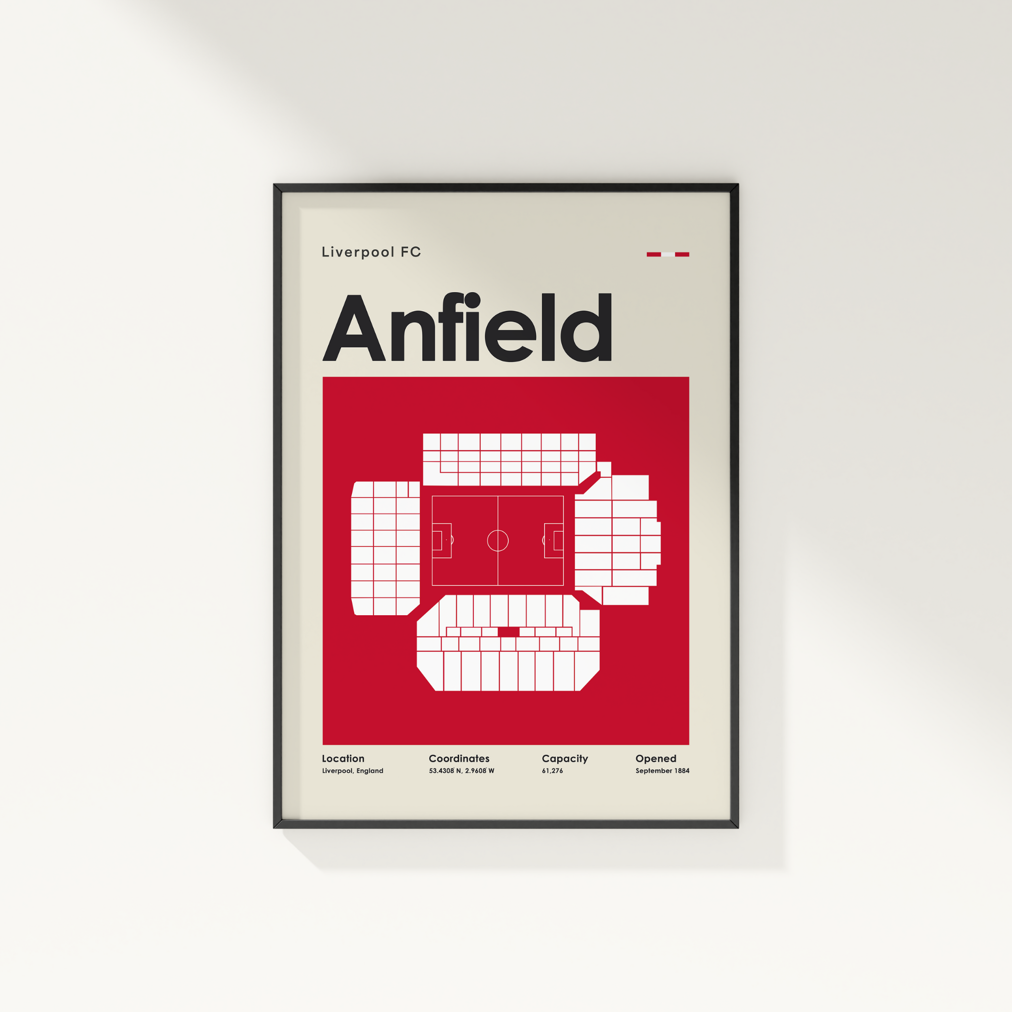Framed poster of Anfield stadium layout for Liverpool FC on a white wall.