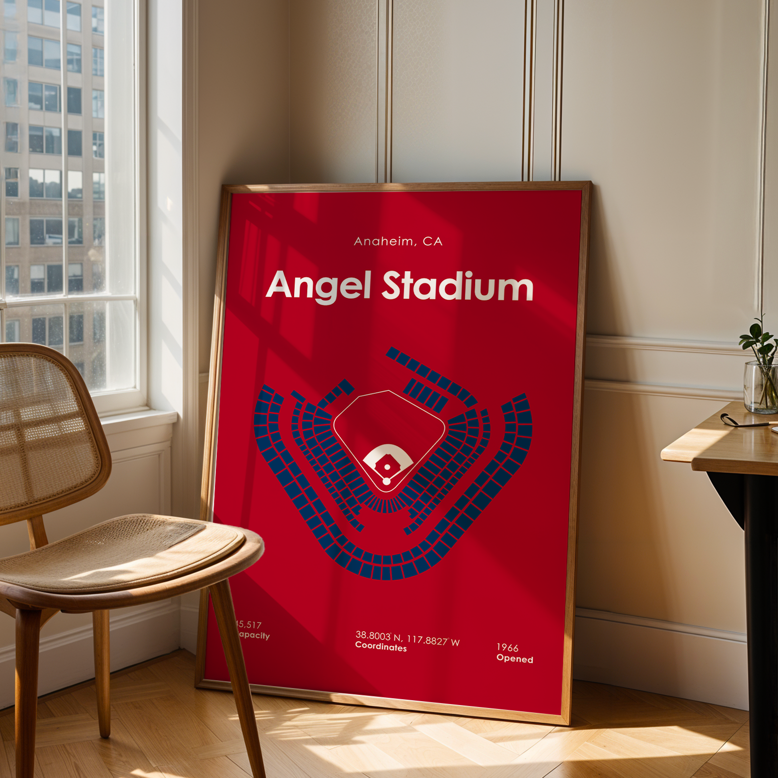 Red poster of Angel Stadium in a room with a chair and table.