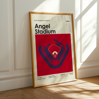 Framed poster of Los Angeles Angels Angel Stadium on a wooden floor with sunlight streaming through a window.