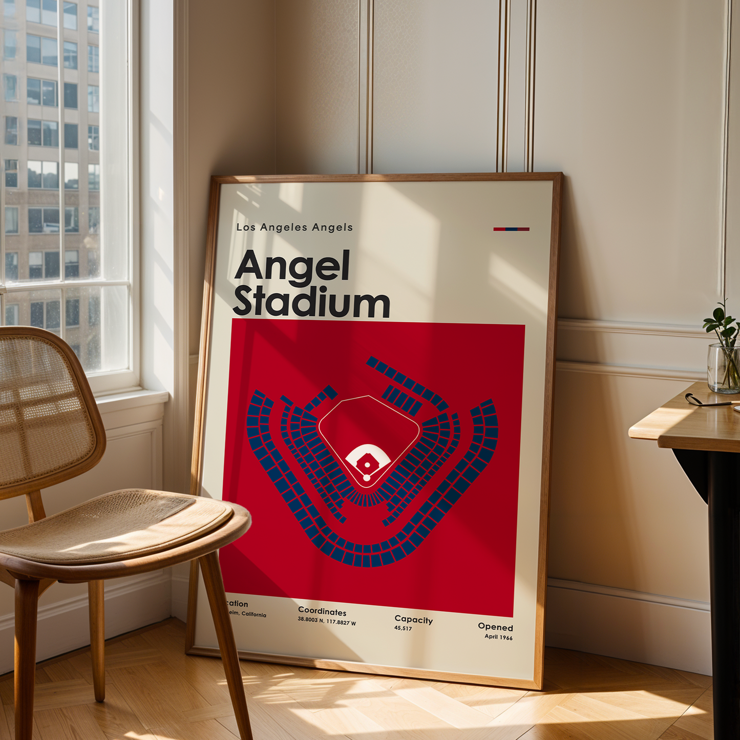 Framed poster of Angel Stadium in a room with a chair and table.