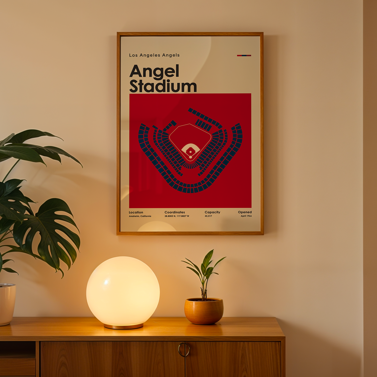 Framed poster of Angel Stadium on a wall above a wooden cabinet with decorative items.