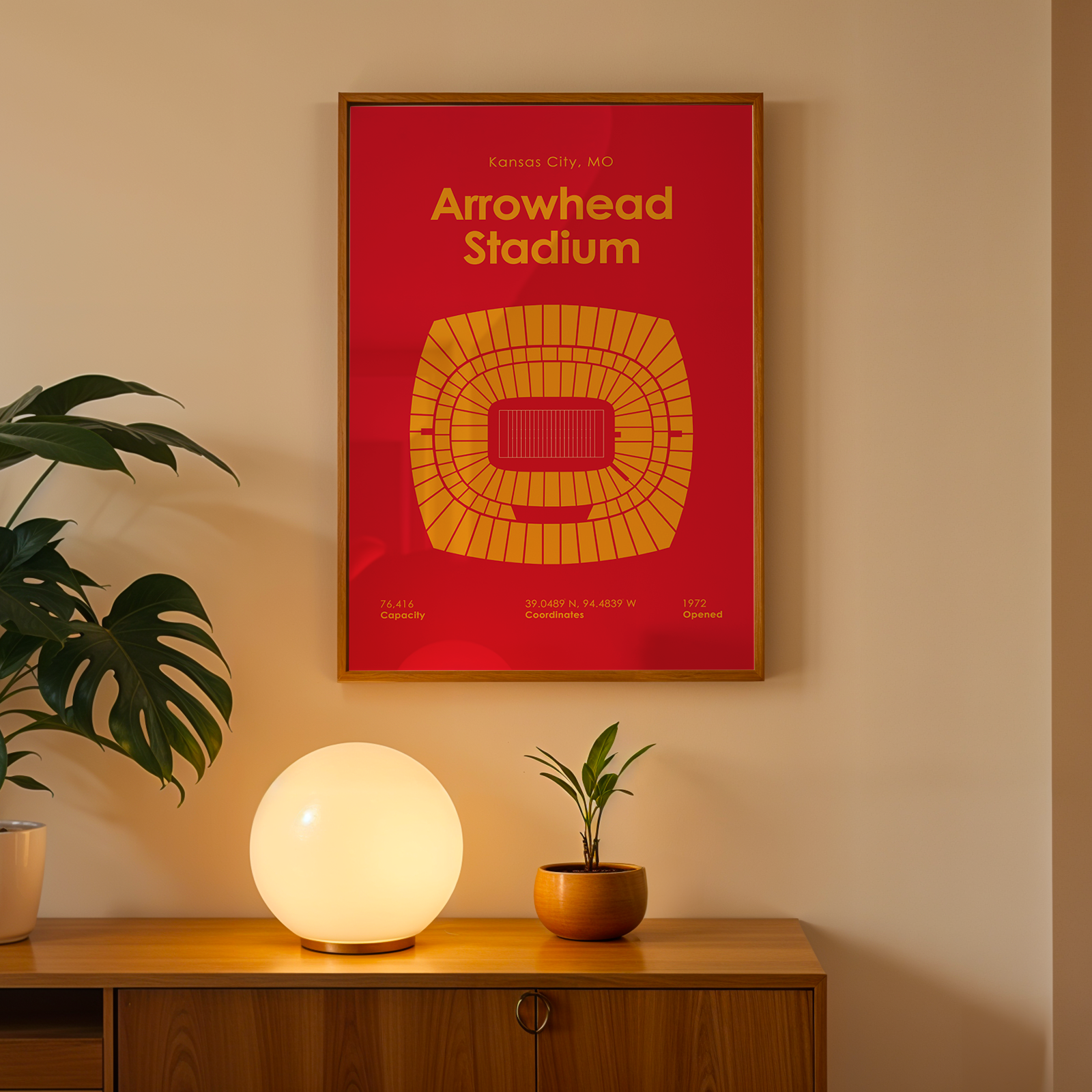 Framed poster of Arrowhead Stadium on a wall above a wooden cabinet with decorative items.
