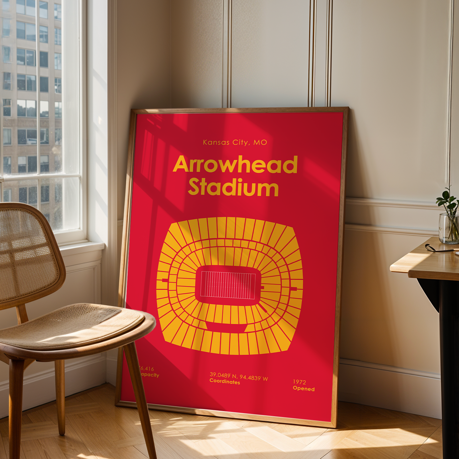 Poster of Arrowhead Stadium in a room with a chair and table.
