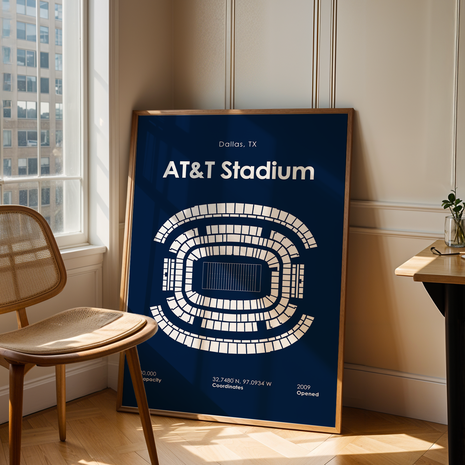 Framed map of AT&T Stadium in Dallas, TX, leaning against a wall next to a chair and table.