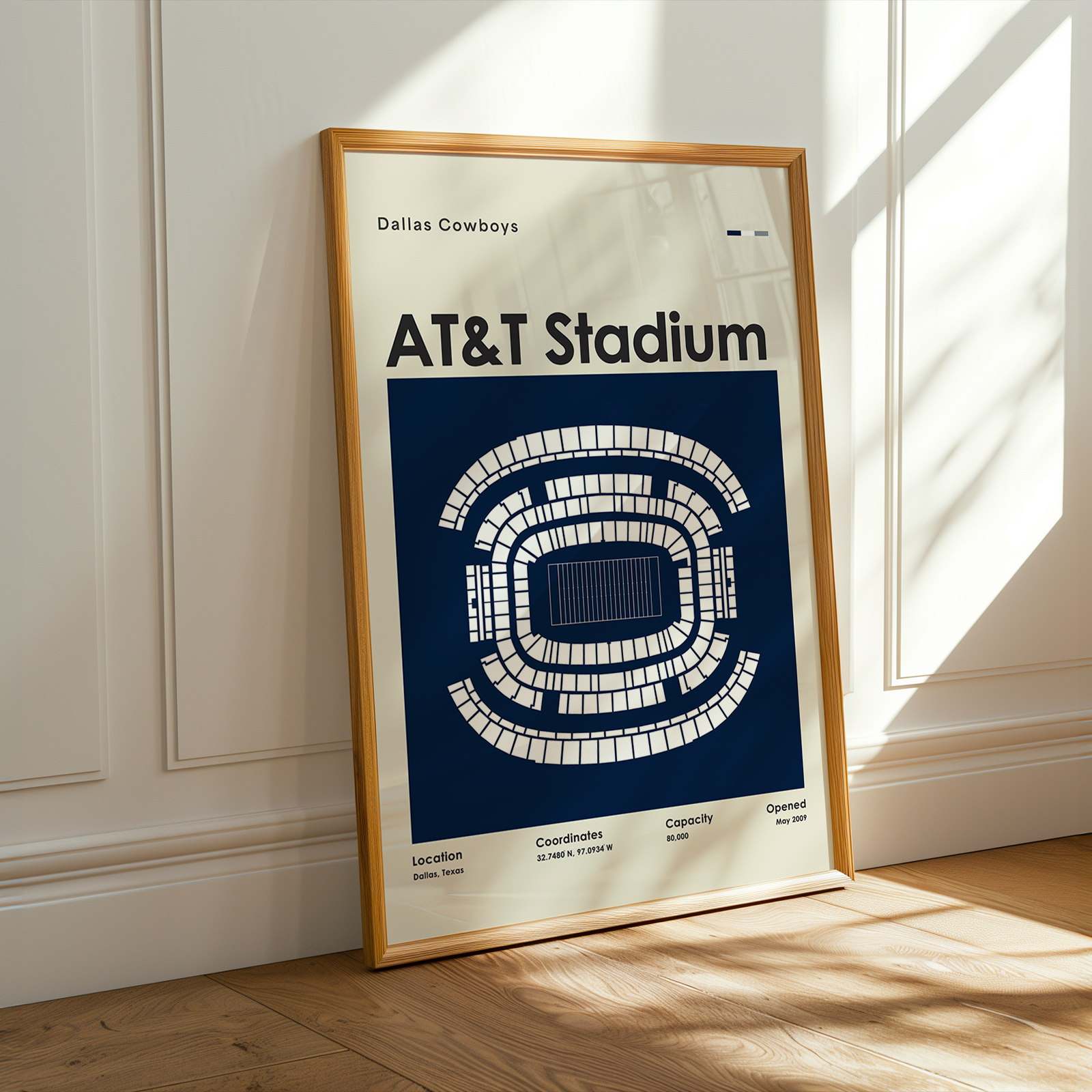 Framed poster of AT&T Stadium layout on a wall with sunlight casting shadows.