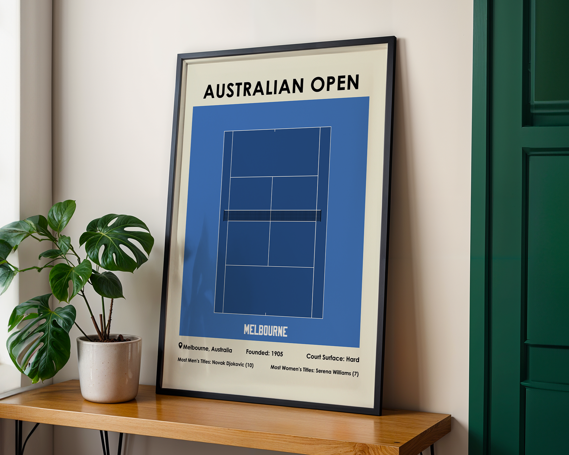 Framed poster of the Australian Open tennis court design on a wall next to a plant.