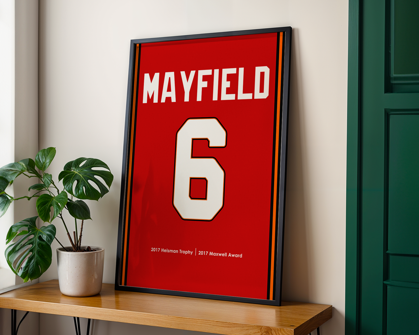 Framed sports jersey with 'MAYFIELD' and number '6' on a wooden shelf.