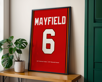 Framed sports jersey with 'MAYFIELD' and number '6' on a wooden shelf.