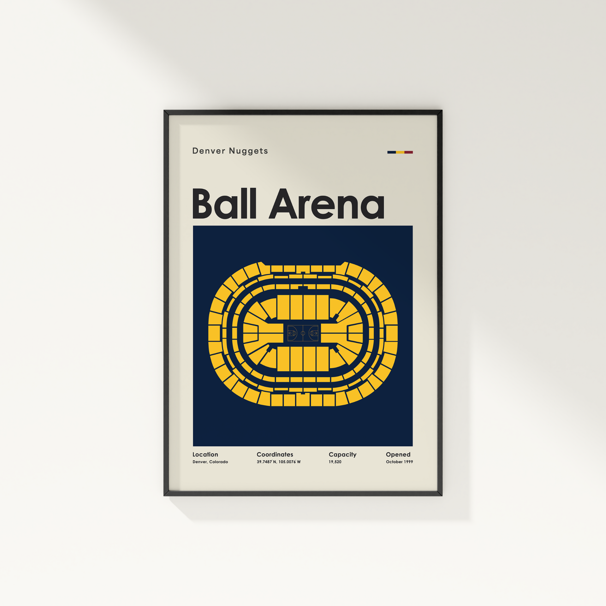 Framed poster of Ball Arena with Denver Nuggets branding on a white wall.