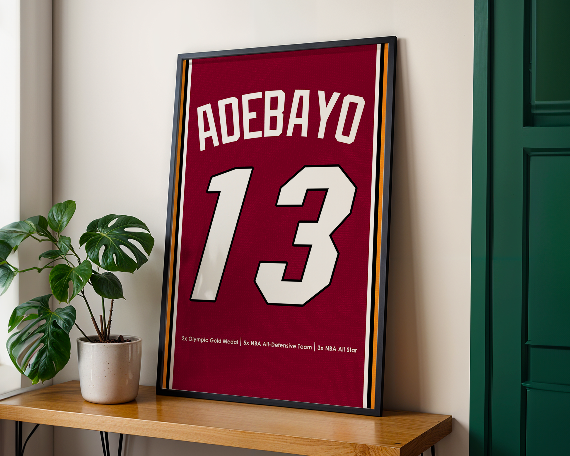 Framed sports jersey with 'Adebayo 13' on a wooden shelf.