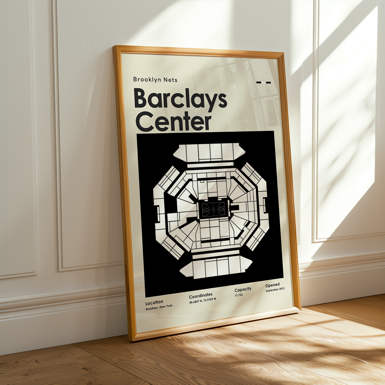 Framed Barclays Center poster on a wall with sunlight casting shadows