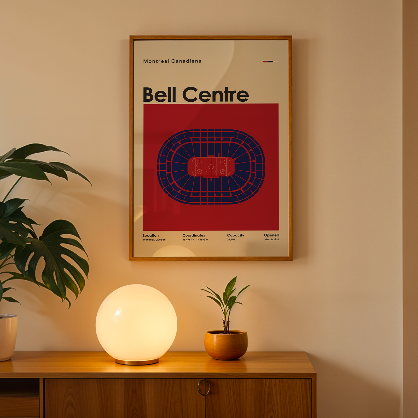 Framed poster of Bell Centre on a wall above a wooden cabinet with decorative items.